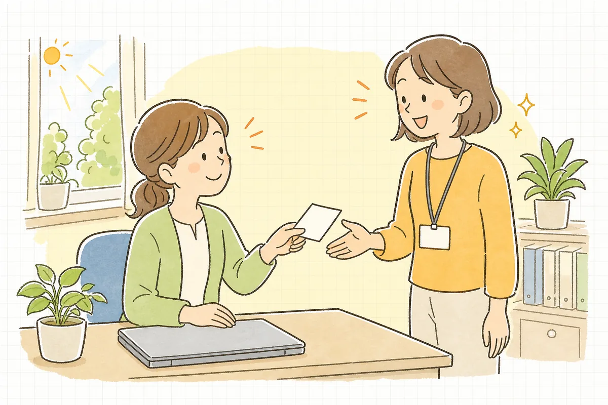 電話を終えた事務担当者が、伝言メモを受け取った相談員と笑顔でうなずき合う、明るい事務室の情景