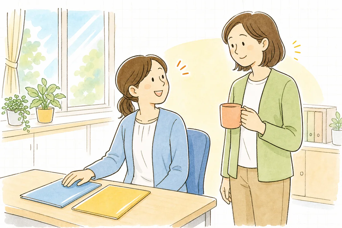整理を終えた2つのクリアファイルを机に置き、ほっとした笑顔で管理者と言葉を交わしている介護事業所の事務担当者
